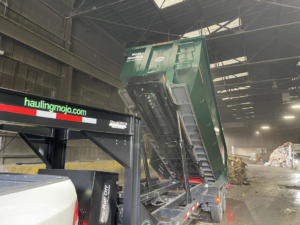 A MoJo Hauling LLC dumpster trailer actively unloading junk at a disposal facility in Bartlesville, OK.