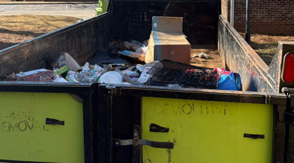 A dumpster or truck bed containing various junk items like cardboard boxes and metal, collected by 247 Junk Removal Greenville SC in Greenville, SC.