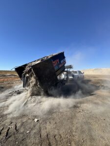 A SpudCity Dumpsters truck unloading construction waste from a dumpster trailer in Caldwell, ID.