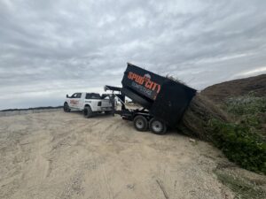 A SpudCity Dumpsters truck unloading green waste from a dumpster trailer at a disposal site in Caldwell, ID.