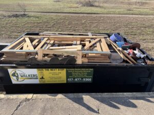A Waste Walkers Dispatch dumpster filled with wooden frames and construction debris in Springfield, MO.