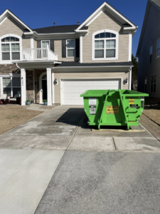 A green DumpStor dumpster placed on a residential driveway, ready for junk removal projects in Charlotte, NC.