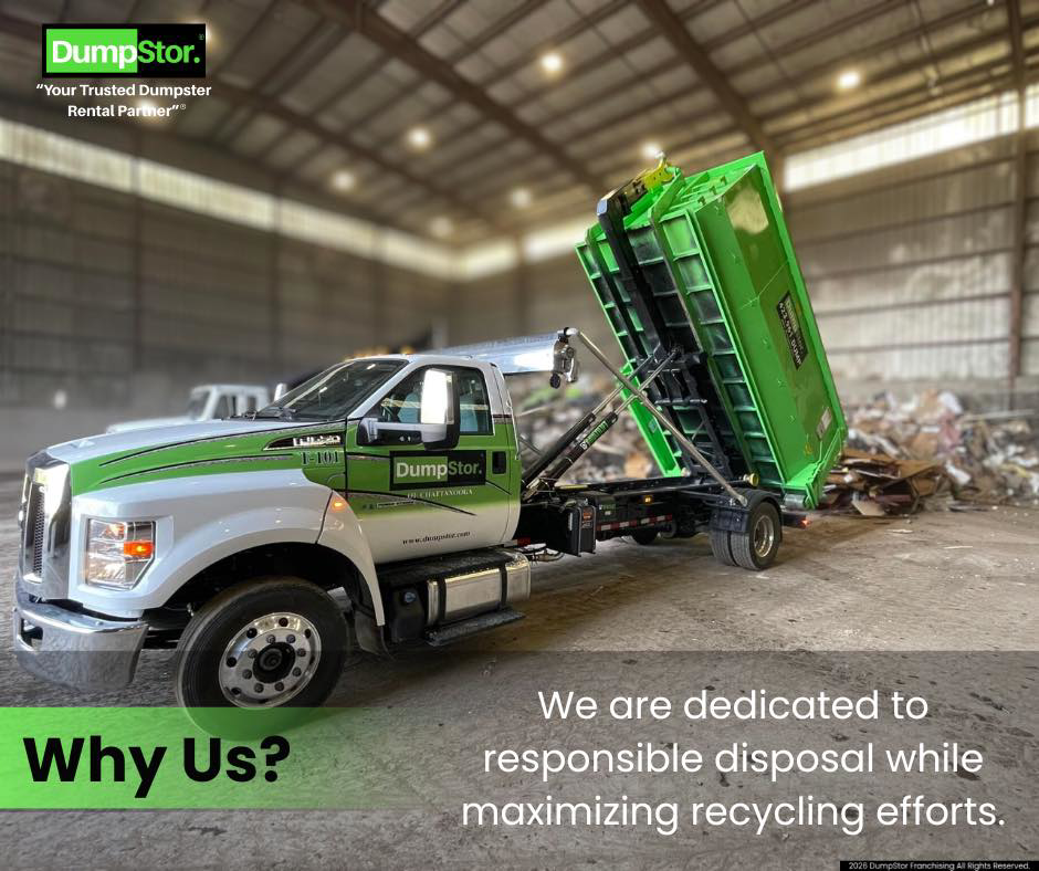 A DumpStor truck unloading a green dumpster filled with debris at a disposal facility in Charlotte, NC.