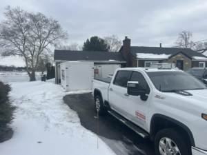 A DuraFloor Epoxy Pros truck and storage container at a snowy residential job site in Akron, OH.