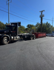 A Dynamic Disposal truck with a roll-off dumpster parked in a lot in Franklin, TN.