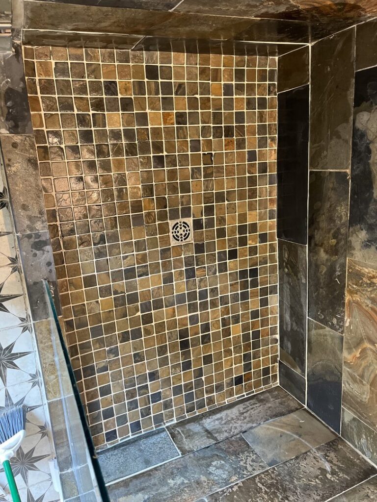 A beautifully tiled shower with small square earth-tone tiles, completed by Hill Renovations LLC in Athens, GA