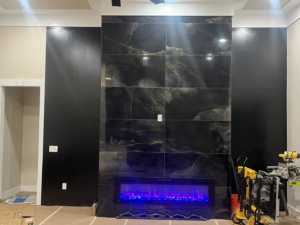 Installation of an electric fireplace and tiled wall by BGI Electric in Pensacola, FL