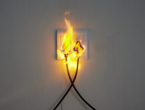 An electrical outlet on fire, indicating a hazardous situation requiring repair by Gragg Electrical Services, LLC in East Canton, OH.