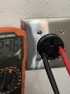 A multimeter being used to test an electrical outlet, demonstrating electrical services by Absolute Integrity Handyman Services Inc in Fresno, CA.