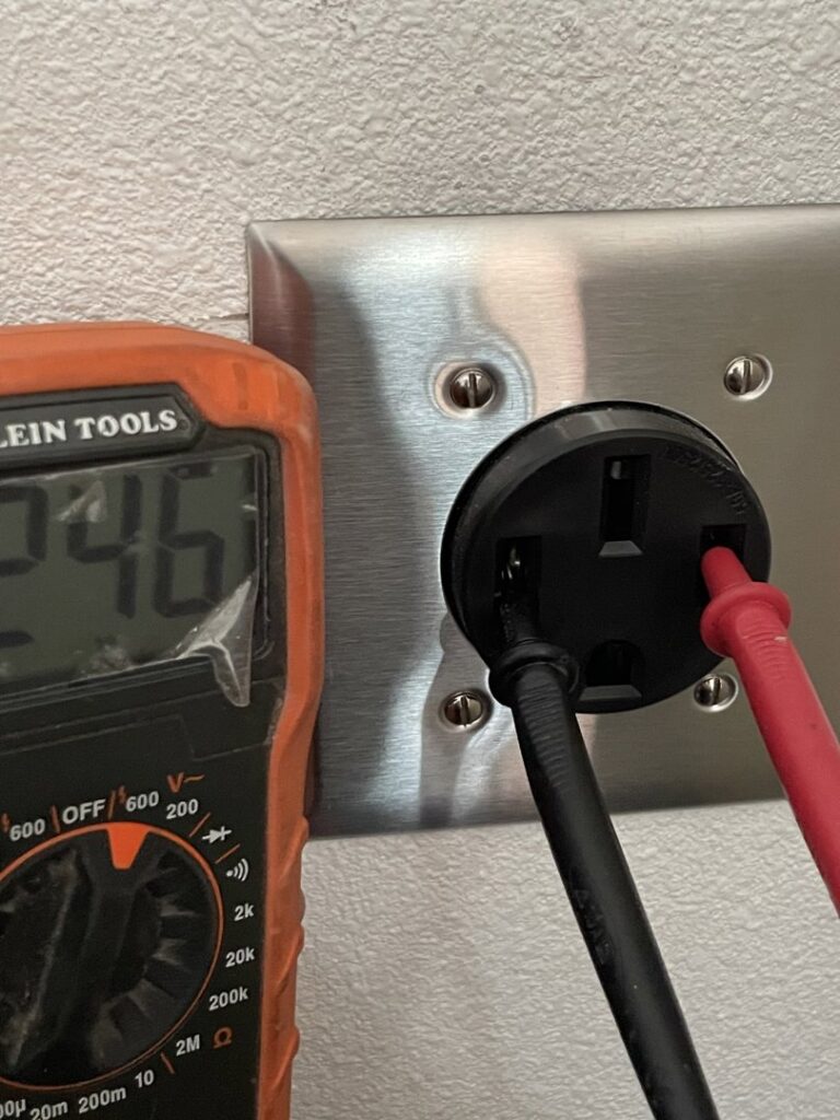 A multimeter being used to test an electrical outlet, demonstrating electrical services by Absolute Integrity Handyman Services Inc in Fresno, CA.