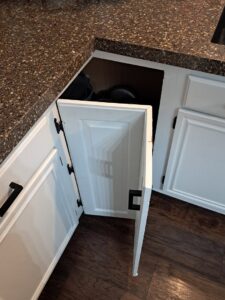 A hand holding a circuit breaker in front of an open electrical panel, showing an electrical repair by Cedar Rapids On Call Handyman Service in Cedar Rapids, IA