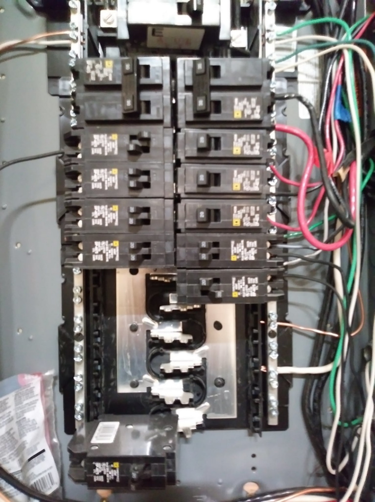 A close-up view of an electrical panel with circuit breakers and wiring, showing electrical work by Doug's Handyman Service in Sioux Falls, SD.