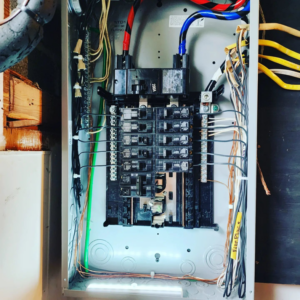An open electrical panel with wiring being worked on by CJM Builders Inc in Wilmington, MA.