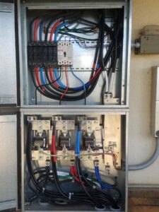 An open electrical panel showing complex wiring and circuit breakers, a service provided by Delaney's Electric Inc. in Ault, CO.