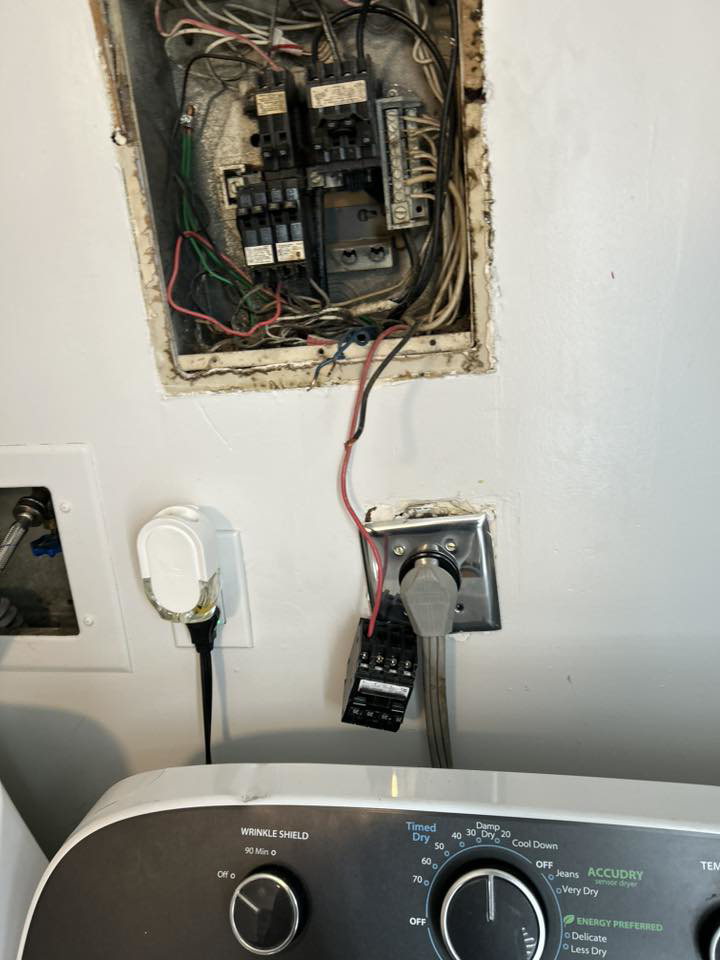 Exposed electrical panel wiring and a washing machine hookup, showing electrical services by Katzenstein llc handyman in Council Bluffs, IA.