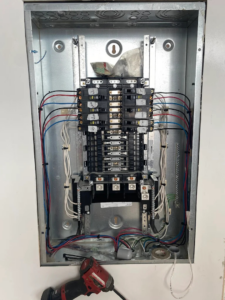 An open electrical panel with wiring and circuit breakers, showing ongoing electrical work by Gragg Electrical Services, LLC in East Canton, OH.