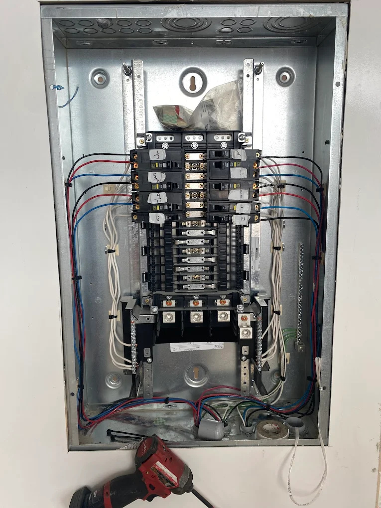 An open electrical panel with wiring and circuit breakers, showing ongoing electrical work by Gragg Electrical Services, LLC in East Canton, OH.