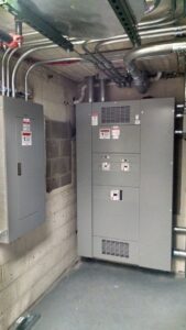 Interior view of an electrical room showing multiple electrical panels and conduit installed by Valiant Electric Inc. in Kenosha, WI.