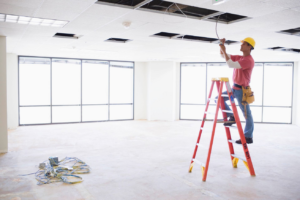 A handyman installing electrical wiring in a ceiling at Nail Builders, Inc. in Littleton, CO