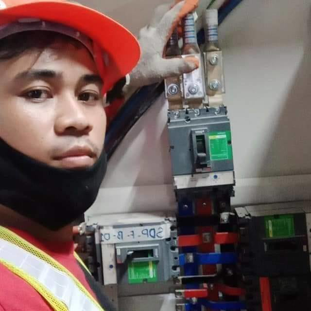 An electrician from Electrician on Call and Home Service working on a circuit breaker panel in Taguig, PH.