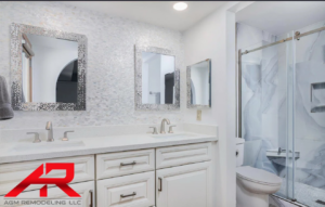 An elegant bathroom renovation featuring a double vanity with white cabinets and a tiled walk-in shower by AGM Remodeling LLC in Scottsdale, AZ.