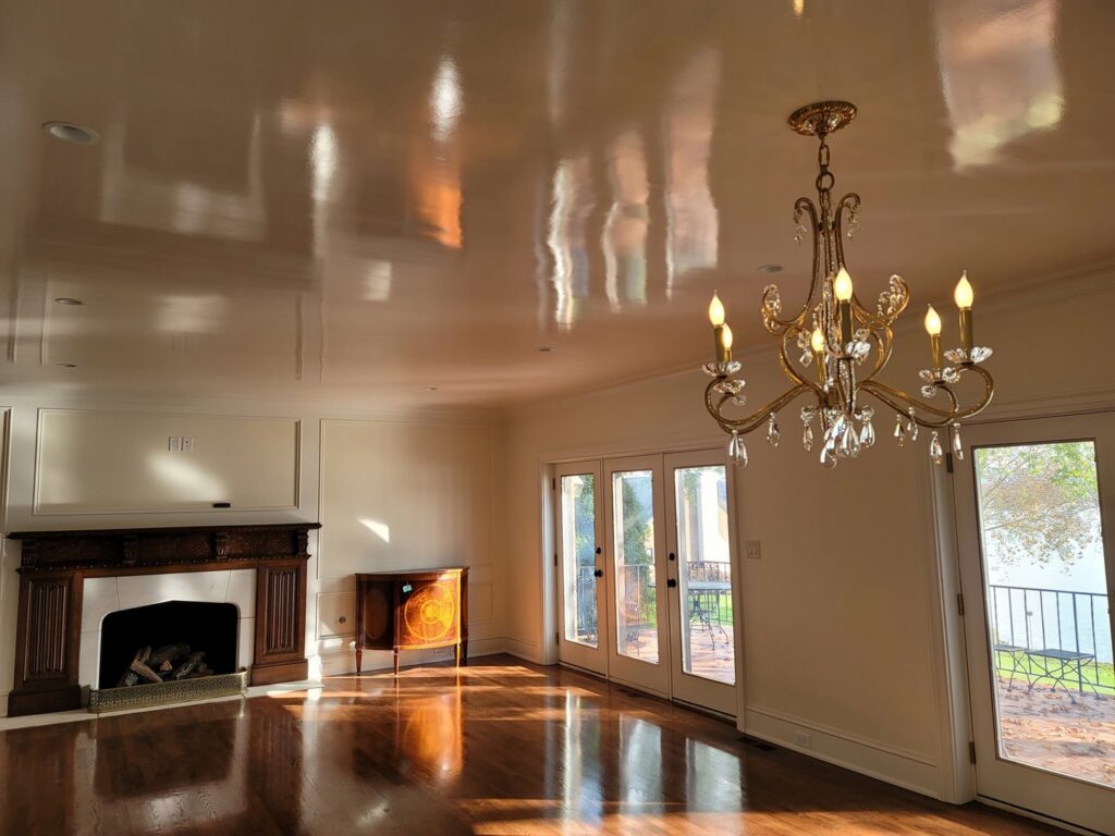 An elegant living room with a classic fireplace, hardwood floors, and a chandelier by Painting Pros of Knoxville in Knoxville, TN.