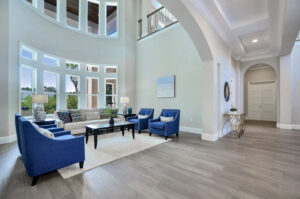 An elegant living room interior with high ceilings and large windows, part of a home built by TamLin Homes Inc in Tampa, FL
