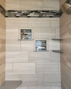 An elegant tiled shower featuring two recessed niches with a decorative accent strip, completed by Ace Tile & Finishing LLC in Philadelphia, PA.