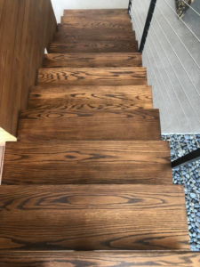 An elegant wooden staircase with a modern railing, expertly installed by Blackhawk Floors, Inc. in Scottsdale, AZ