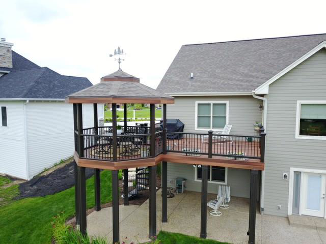 An elevated deck with a custom gazebo and spiral staircase, expertly built by Screwheads Decking And Supply Store in Racine, WI