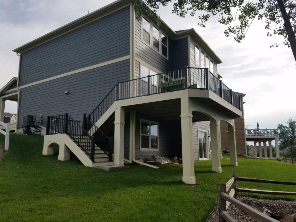 House exterior with a newly built elevated deck and stairs by Tschida Construction in Cologne, MN.