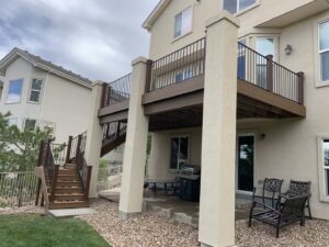 An elevated deck with sturdy columns, stairs, and railings, built by Lnk Deck & Remodels, LLC in Aurora, CO.