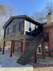 An elevated sunroom addition with stairs leading to a backyard by Four Seasons of River City in Columbus, GA.