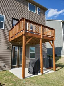 A newly constructed or stained elevated wooden deck with stairs, built by Prime Painting in Charlotte, NC.