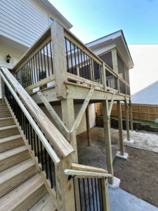 Exterior view of a newly built elevated wooden deck and stairs by Housworth Construction in Suwanee, GA