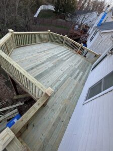 An elevated wooden deck with sturdy railings, showcasing handyman construction by McIntosh Construction in Des Peres, MO.