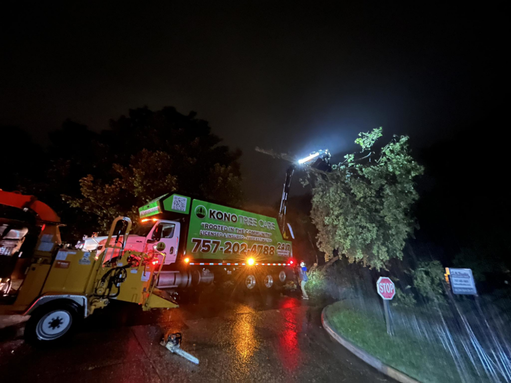 Kono Tree Care performing emergency tree removal at night with a boom truck and chipper in Virginia Beach, VA.