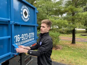 An employee closing the back of a Black Diamond Junk Removal truck after a job in Bedford Heights, OH.