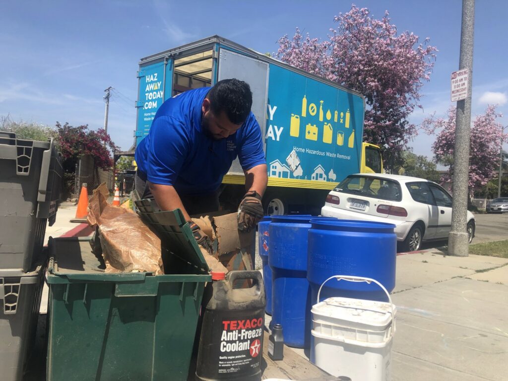 A Hazawaytoday.com employee loading hazardous waste materials into a truck for removal in El Segundo, CA