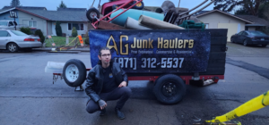 An AG Junk Haulers employee standing in front of a trailer filled with various junk items, showcasing their service in Salem, OR.