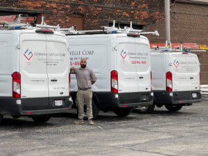 A Gorman-Lavelle Corp employee standing proudly with a fleet of service vans in Cleveland, OH