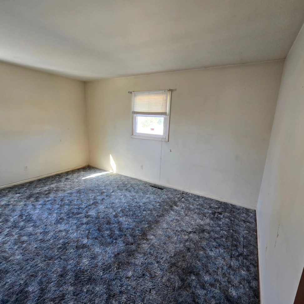 An empty bedroom with blue carpet and light walls, ideal for a painting or flooring handyman project by 1st State's Finest LLC in Middletown, DE.