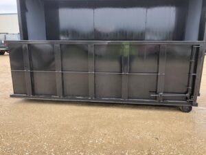 The clean interior of an empty black dumpster from NID Dumpster Rental, ready for junk removal in Nashua, IA.