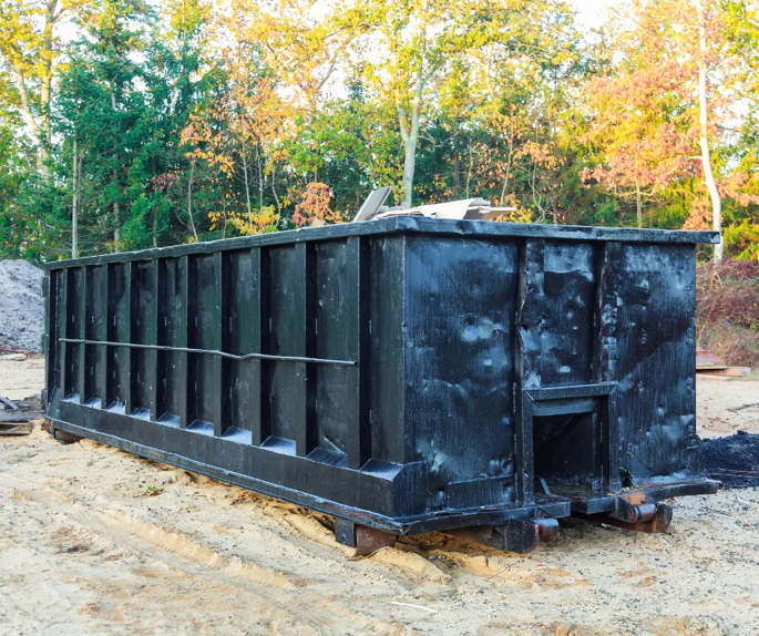 An empty black roll-off dumpster, typical for junk removal services by Century Waste Management in Sterling Heights, MI.