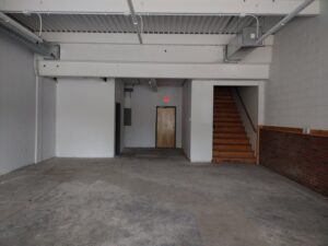 An empty commercial space with exposed ceiling and concrete floor, ready for renovation by Brothers Home Improvement in East Hartford, CT