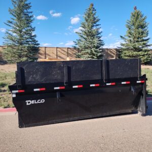 An empty DELCO roll-off dumpster provided by T-Rex Service LLC for junk removal in Cheyenne, WY.