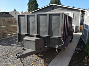 An empty dump trailer parked in a residential driveway, ready for junk removal services by Gorilla Hauling in Kent, WA.