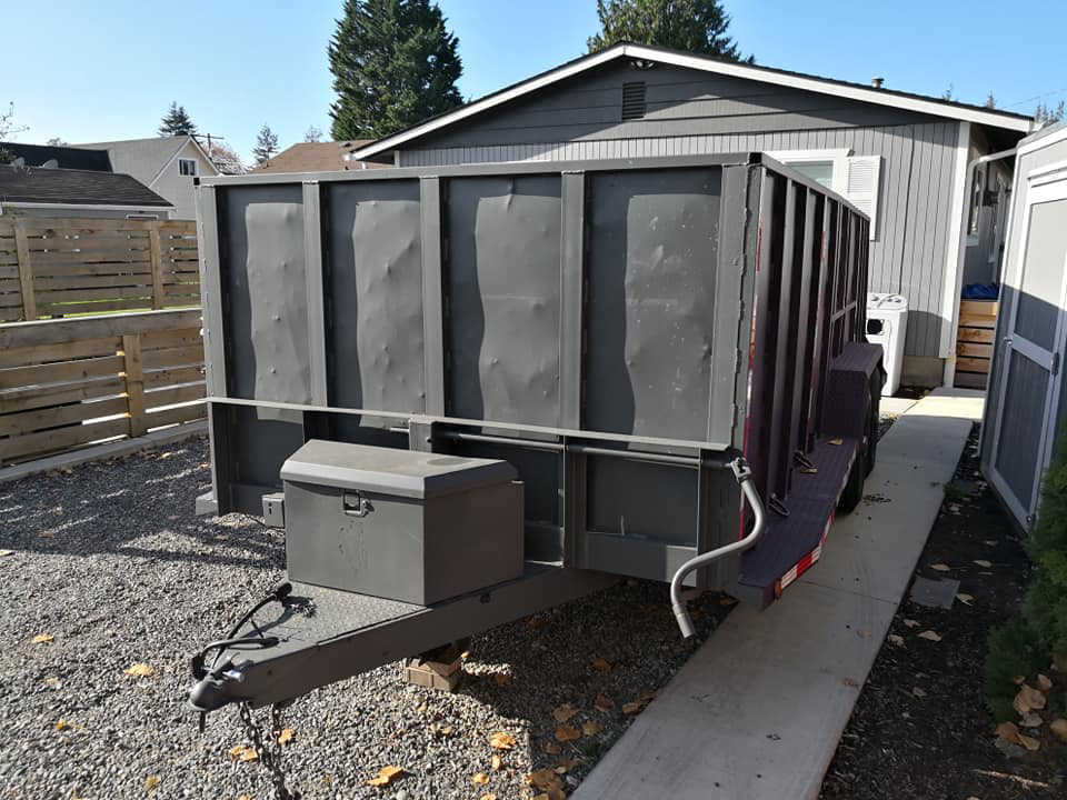 An empty dump trailer parked in a residential driveway, ready for junk removal services by Gorilla Hauling in Kent, WA.