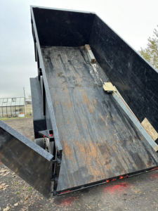 An empty dump trailer with its bed raised, ready for or after a junk removal job by Timber Moose Dynamics LLC in Spokane, WA.