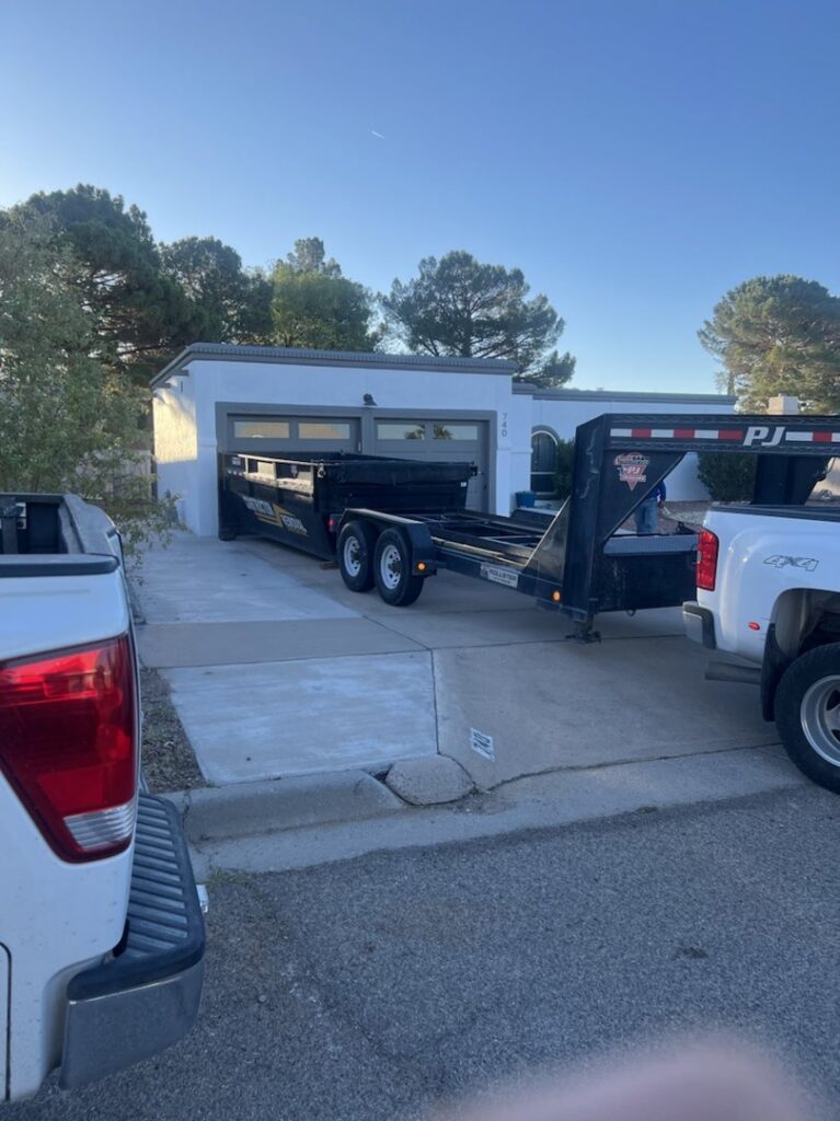An empty dump trailer parked in a residential driveway, ready for junk removal by Construction Removal Services Inc. in El Paso, TX.